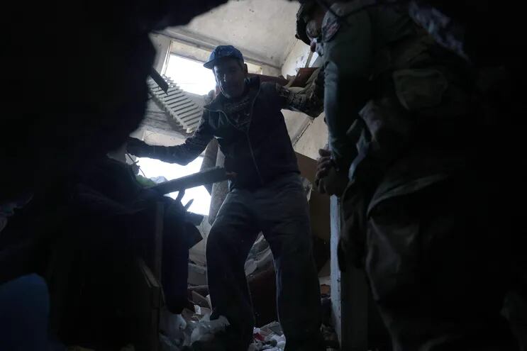 Un policía militar ucraniano evacúa a civiles de un edificio dañado por un bombardeo ruso cerca de Avdivka, el pasado 15 de abril.
