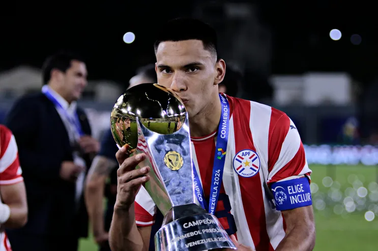Diego Gómez, futbolista de la selección paraguaya, besa el trofeo de campeón del Preolímpico 2024 en los festejos en el estadio Nacional Brígido Iriarte, en Caracas, Venezuela.