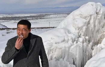 El jefe del distrito de Syn-Tash, Maksat Dzholdoshev, prueba el trozo de hielo del glaciar artificial en un desfiladero de montaña cerca del pueblo de Syn-Tash, a unos 60 kilómetros de Bishkek.