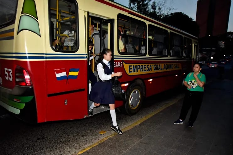 Estudiantes descienden de una unidad de transporte público para dirigirse al centro educativo en el microcentro de Asunción.
