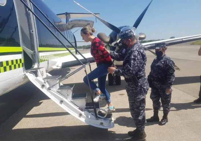 Policías salvadoreños suben  Margareth Lizeth Chacón Zúñiga al avión que la llevó a Colombia.