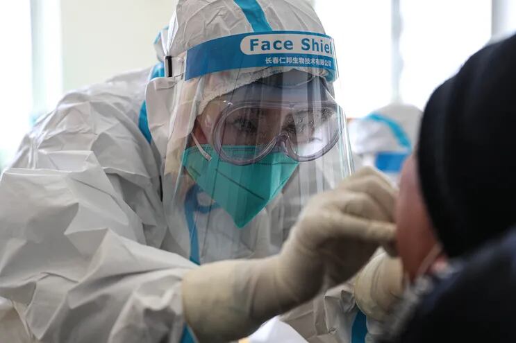 Un trabajador médico toma una muestra de hisopo de un residente para realizar la prueba del coronavirus COVID-19 en Shenyang, en la provincia de Liaoning, en el noreste de China.