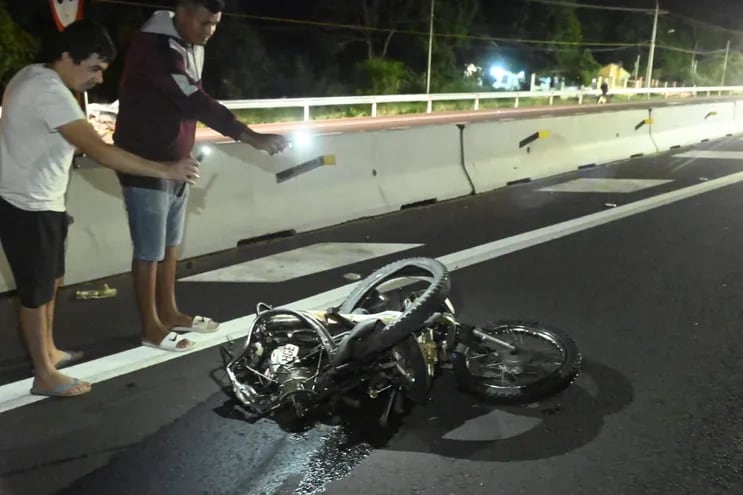 Dos personas captan imágenes de la motocicleta en la que viajaban una pareja y sus tres hijitos. Todos fallecieron esta madrugada al ser embestidos por un automóvil.