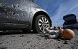 Un automóvil acribillado y una muñeca perdida en el asfalto luego de los ataques en  Irpin, norte de Kiev. (AFP)