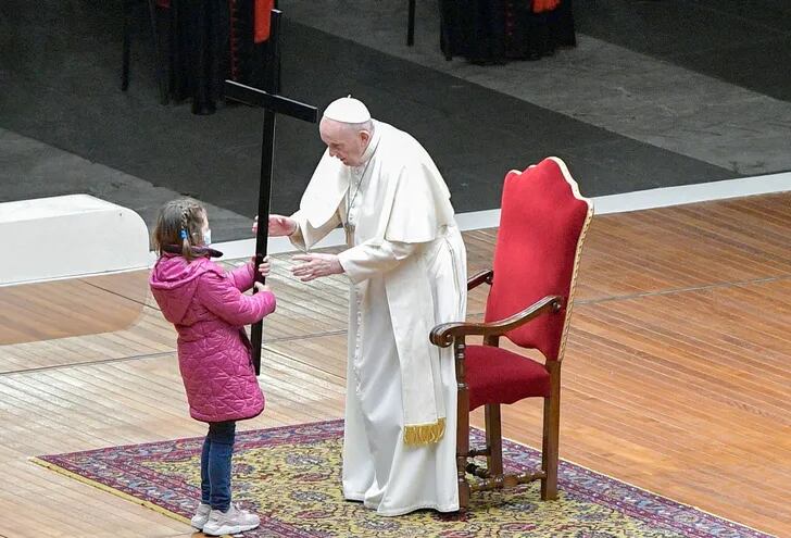 El papa Francisco recibe de una niña la cruz en la conclusión del vía crucis, en la   plaza de San Pedro.