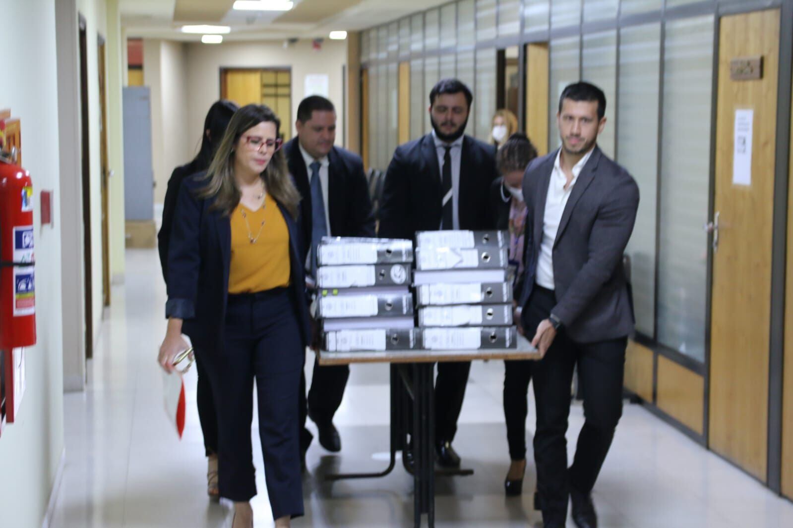 Kattya González junto a funcionarios de la Cámara Baja llevando la pila de documentos para darle entrada en Diputados.