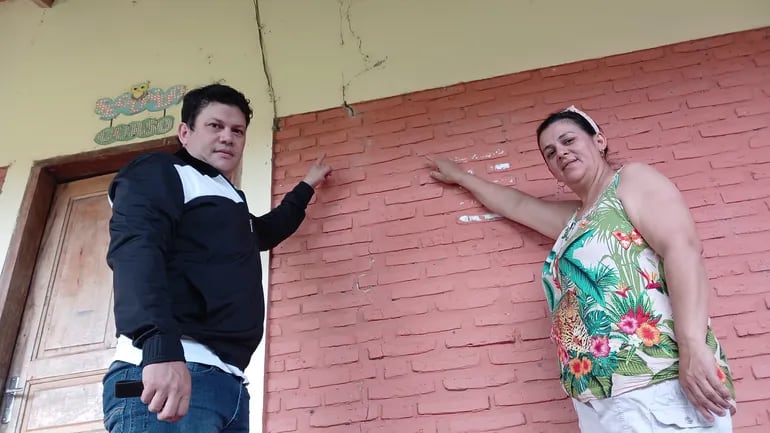 El encargado de despacho del colegio nacional San Rafael, Heber López, y María Liliana Giménez, familia de alumnos, muestran una enorme fisura en la pared.