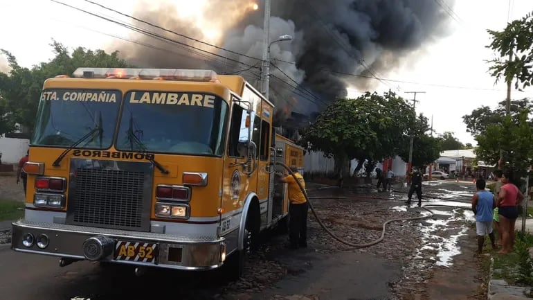 Bomberos de Lambaré intentan combatir el incendio, este jueves en Ita Enramada.