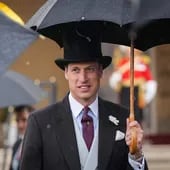 El Príncipe Guillermo de Gran Bretaña llegando con un paraguas a la Fiesta en el Jardín del Soberano, en el Palacio de Buckingham.