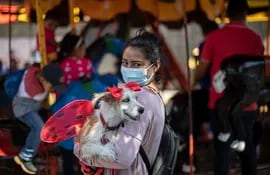 A woman carries her dog to be blessed by Saint Lazarus, in Monimbo neighbourhood in Masaya, about 35 km south of Managua, on March 21, 2021. - According to tradition in Nicaragua, faithfuls ask Saint Lazarus for the health of their dogs and pay these favours back by bringing their pets dressed in costumes to attend mass in honour of the saint. (Photo by Inti OCON / AFP)