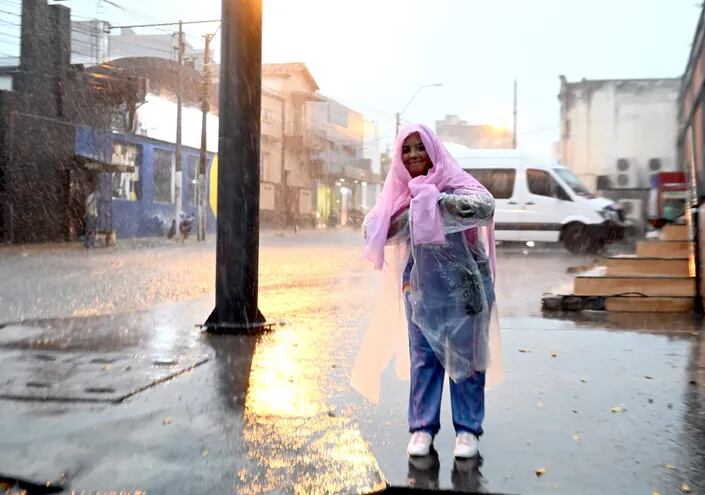 Una mujer bajo la lluvia en el centro de Asunción, el jueves.