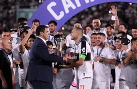Robert Harrison (i) entrega la Copa Paraguay a Antolín Alcaráz, capitán de Olimpia.