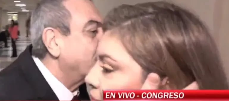 En la imagen se observa al diputado Yamil Esgaib acercándose al oído de la periodista Rocío Pereira Da Costa, mientras la mujer se encontraba en un enlace en vivo para su canal.