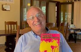 El historiador Kornelius Neufeld sosteniendo una edición del libro "Kaputi mennonita" escrito por Peter P. Klassen que relata los primeros años de asentamiento de los pioneros que colonizaron el Chaco hace casi 100 años.