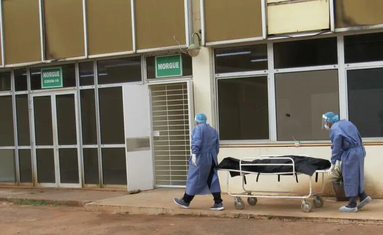 Trabajadores de la Salud transportan un fallecido en el Hospital Nacional.