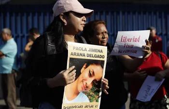 Una mujer muestra un cartel con una fotografía de Paola Delgado, desaparecida desde 2022 e hija de Verónica Delgado, detenida bajo el régimen de excepción, durante una protesta afuera de una sede judicial en San Salvador (El Salvador).