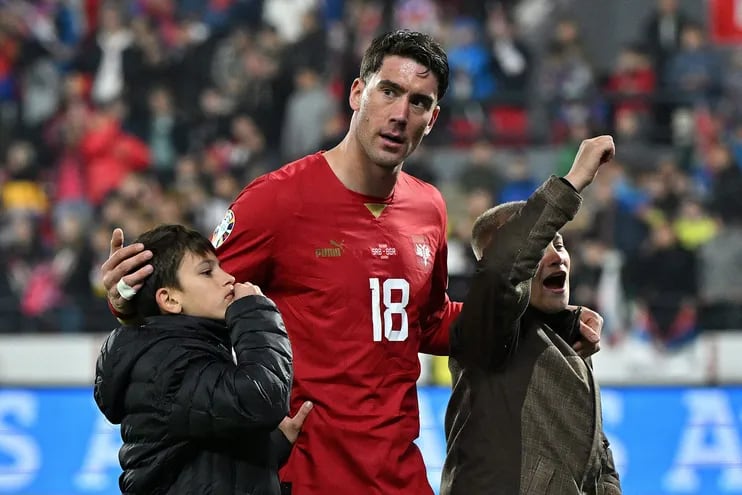 Dusan Vlahovic, jugador de Juventus de Italia y una de las figuras de la selección de Serbia, celebra centro del campo con dos niños la clasificación de su selección a la Eurocopa 2024.