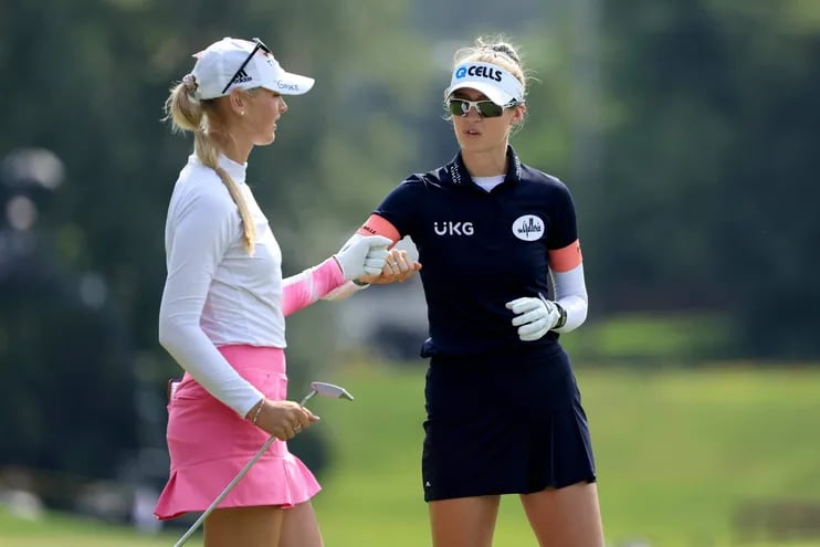 Jessica Korda (L) y su hermana Nelly Korda se saludan puño con puño durante una partida de golf en Midland, Michigan.