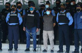El expresidente de Honduras, Juan Orlando Hernández (esposado de manos y pies) acompañado de las autoridades policiales de su país y de EE.UU.