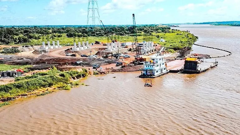 Ya se ven las embarcaciones que brindarán apoyo en el proceso de montaje de los  pilotes  en el lecho del río Paraguay.