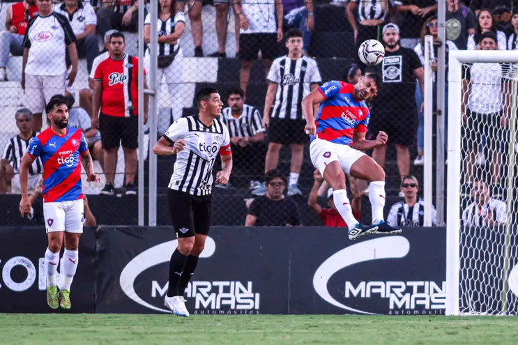 Juan Patiño (d), defensor de Cerro Porteño, defiende una pelota con un cabezazo durante el duelo contra Libertad por la décima fecha del torneo Apertura 2023 del fútbol paraguayo en el estadio La Huerta, en Asunción.
