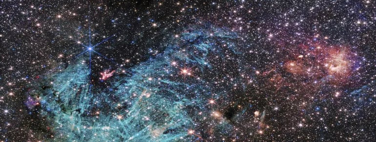La última imagen del telescopio espacial James Webb muestra una porción del denso centro de nuestra galaxia con un detalle sin precedentes. Se calcula que unas 500.000 estrellas brillan en esta imagen de la región de Sagitario C (Sgr C), junto con algunos rasgos aún no identificados. La última imagen del telescopio espacial James Webb muestra una porción del denso centro de nuestra galaxia con un detalle sin precedentes, incluyendo características nunca antes vistas que los astrónomos aún tienen que explicar. La región de formación estelar, denominada Sagitario C (Sgr C), se encuentra a unos 300 años-luz del agujero negro supermasivo central de la Vía Láctea, Sagitario A*, informan sendos comunicados de la Agencia Espacial Europea (ESA) y la agencia espacial estadounidense NASA.En el corazón de este joven cúmulo se encuentra una protoestrella masiva con una masa 30 veces superior a la de nuestro sol.