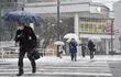 Transeúnes cruzan una avenida bajo una nevada en Toyama, Japón, este martes.