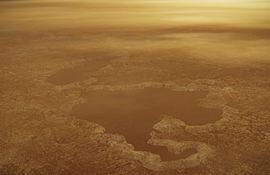 Dibujo artístico conceptual cedido por la NASA muestra un lago de agua en el polo norte de la luna Titán del planeta Saturno. Los aparentes lagos de agua en Titán, la luna mayor del planeta Saturno, pueden ser en realidad gases depositados en cuencas formadas por explosiones de cráteres que están en estado líquido, según un estudio publicado este lunes.