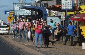 Varias personas esperando buses en la zona de la Ruta Transchaco y la avenida Artigas.