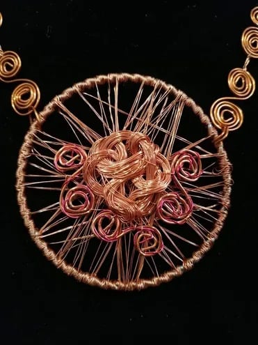 Pieza elaborada por Nimia Portillo con hilos de cobre reciclado en variadas formas y tonos. Collar y medallón.