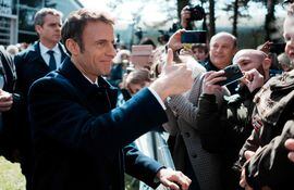 El presidente francés y candidato a la reelección, Emmanuel Macron, saluda a sus partidarios luego de depositar su voto.