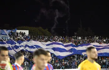 Los hinchas de 2 de Mayo extienden una bandera para recibir al equipo en el partido frente a Cerro Porteño en el Río Parapití.