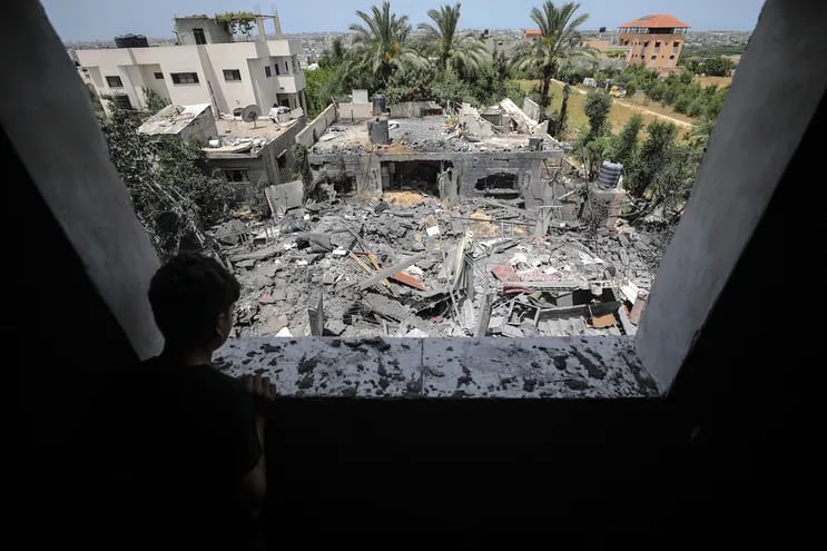 Un niño observa desde una ventana los restos de la casa de la familia Abu Khatir tras resultar alcanzada en un ataque con cohetes del Ejército de Israel.