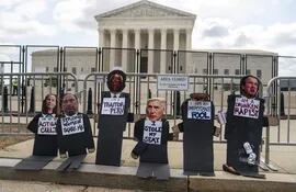 Figuras de los miembros conservadores de la Corte Suprema de Estados Unidos, pegadas a la barrera que protege el edificio en Washington DC.