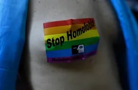 Un miembro de la comunidad de Lesbianas, Gays, Bisexuales, Transgénero, Intersex y Queer (LGBTIQ) lleva pegada al pecho una calcomanía con la leyenda "Paren la homofobia".