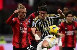Dusan Vlahovic (d), delantero serbio de Juventus, disputa el balón con Simon Kjaer, zaguero danés del AC Milan, durante el partido que el conjunto de Turíon ganó 1-0 en el mítico estadio San Siro.