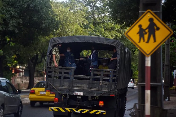 Ante la escasez del servicio de transporte público, la gente se traslada en camiones de las Fuerzas Armadas.