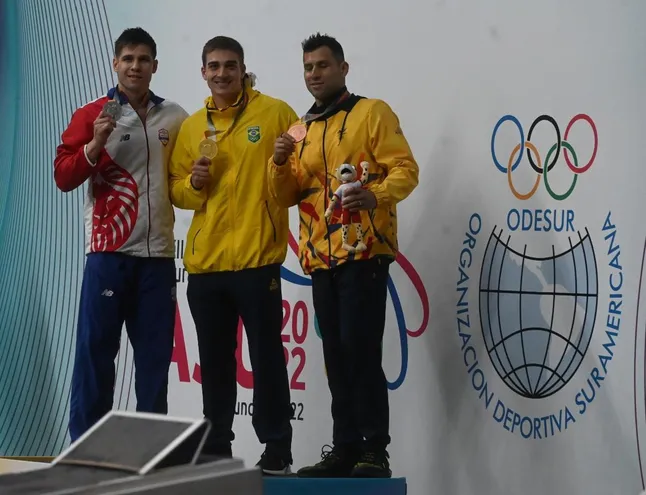 Charles Hockin, nadador paraguayo (i), celebra con la medalla de plata después de subir al podio en los 50 metros espalda.