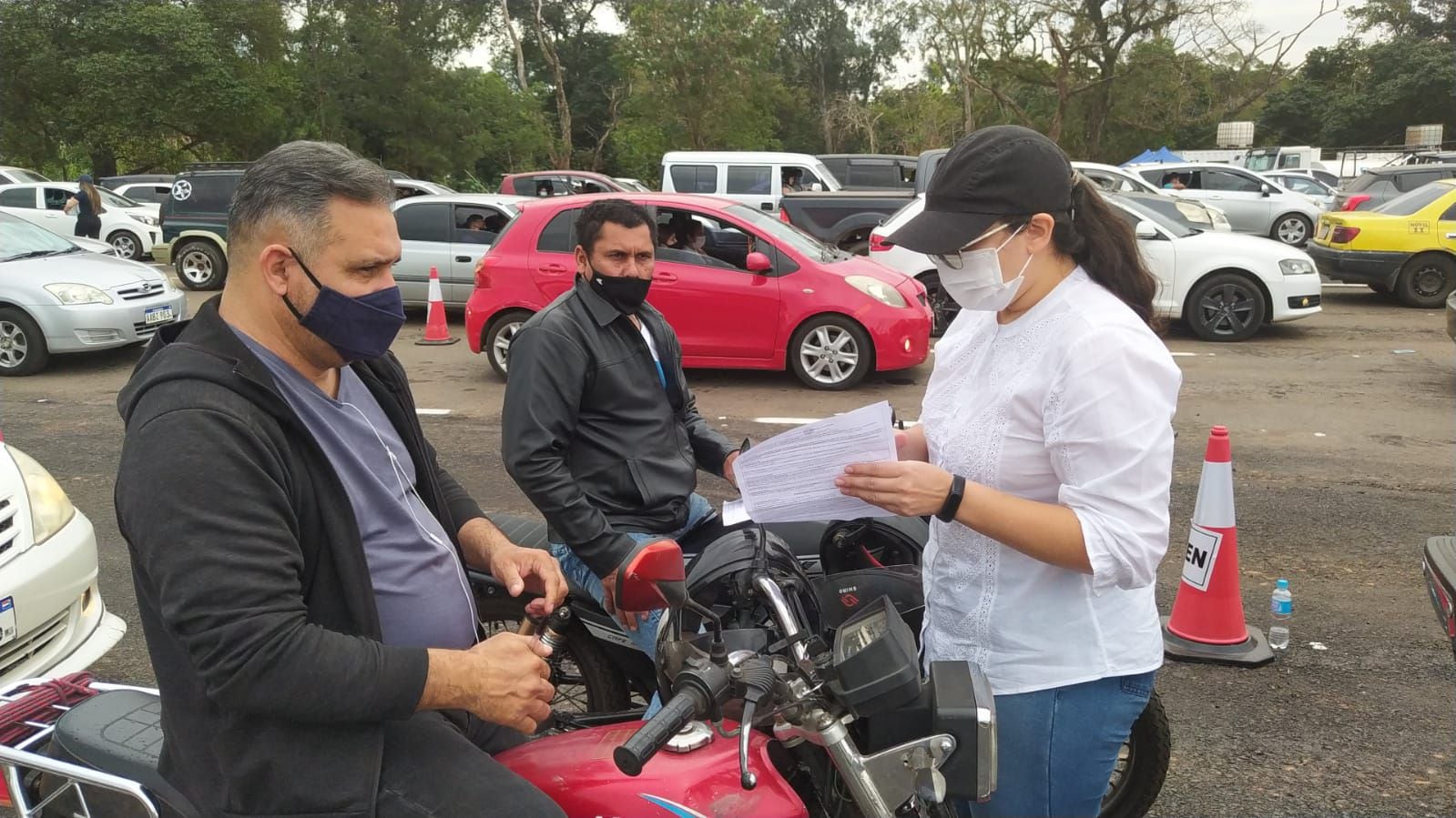 Funcionarios públicos entregan las hojas de consentimiento para la vacunación en el autódromo Rubén Dumot el 14 de julio de 2021.