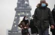 Fotografía de archivo: peatones con tapabocas circulando en zona de la Torre Eiffel, París.
