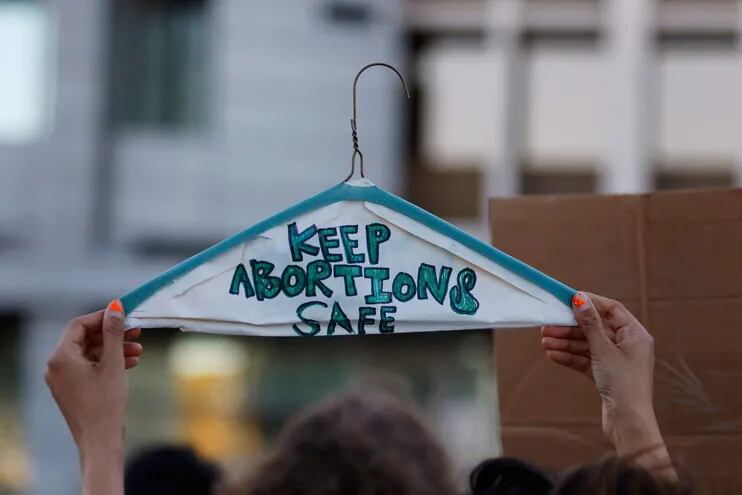 Durante una manifestación en Estados Unidos, una persona sostiene una percha metálica como símbolo de los derechos reproductivos de la mujer, con la inscripción "mantegamos los abortos seguros".