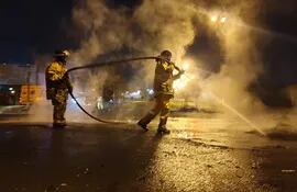 Mujeres bomberas trabajan en la zona del kilómetro 10 de Ciudad del Este esta madrugada, tras los incidentes.