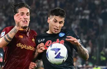 El italiano Nicolo Zaniolo (i), de Roma, disputa el balón con el uruguayo Mathías Olivera, de Napoli.
