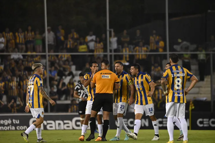 Los jugadores del Sportivo Luqueño reclaman al árbitro Blas Romero en un partido frente a Libertad por la segunda fecha del torneo Apertura 2024 del fútbol paraguayo en el estadio La Huerta, en Asunción.