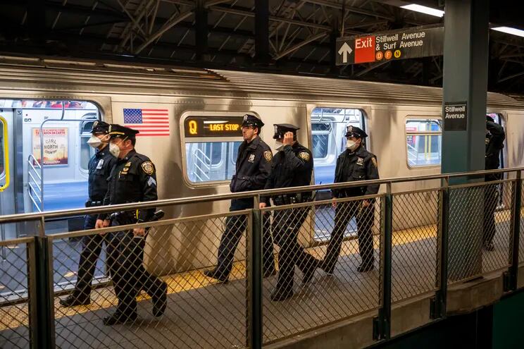 Agentes de la Autoridad Metropolitana de Transporte de Nueva York se encargan de vaciar de pasajeros los vagones de un tren subterráneo tras su última parada en la estación de Coney Island, en Brooklyn.