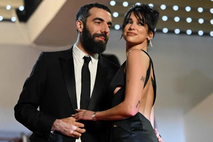 El director francés Romain Gavras y la cantante británica Dua Lipa llegando juntitos a la proyección del filme "Omar la Fraise" en el Festival de Cannes. (Patricia DE MELO MOREIRA/AFP)