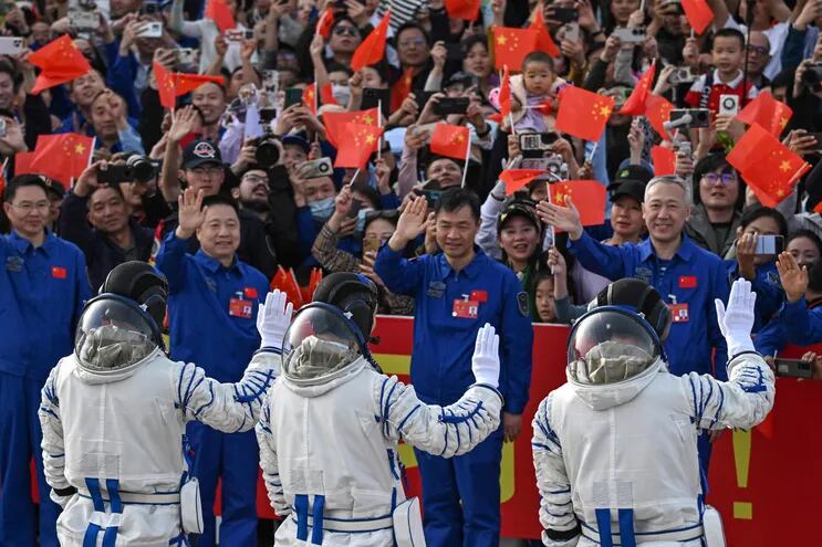 Los astronautas de la misión espacial Shenzhou-18 de China (de izquierda a derecha) Li Guangsu, Li Cong y Ye Guangfu saludan durante una ceremonia de salida antes de abordar un autobús que los llevará a la nave espacial Shenzhou-18 en el Centro de Lanzamiento de Satélites de Jiuquan en el desierto de Gobi en noroeste de China.