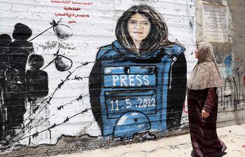 Una mujer pasa junto a un mural dedicado a la periodista palestina Shireen Abu Akleh, en Belén.