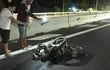Dos personas captan imágenes de la motocicleta en la que viajaban una pareja y sus tres hijitos. Todos fallecieron esta madrugada al ser embestidos por un automóvil.
