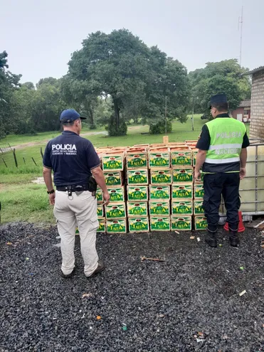 Agentes del departamento Anticontrabando de la Policía verifican parte del cargamento de tomate incautado.